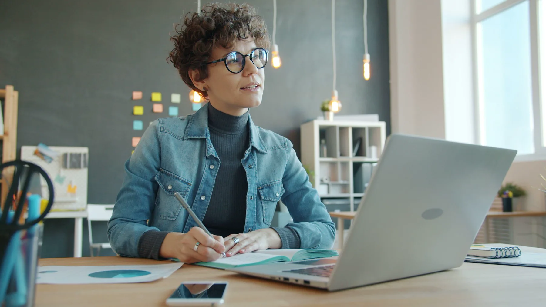 A small business owner working at a desk with a notebook