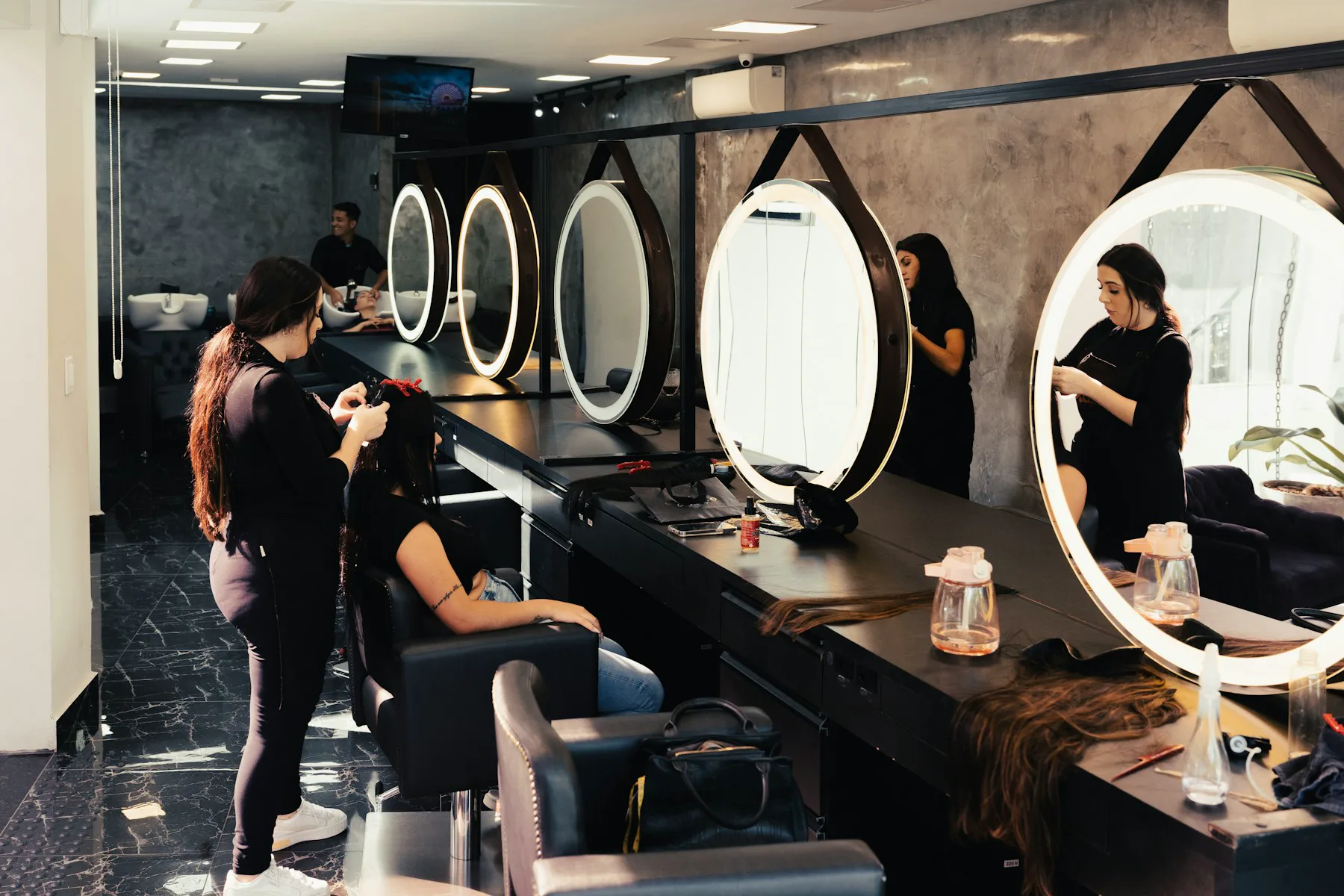A stylist working with a client at a salon mirror