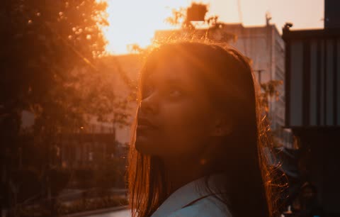 A woman looks up through warm evening light